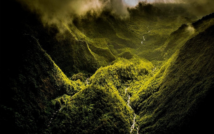 Green mountains with a river and clouds