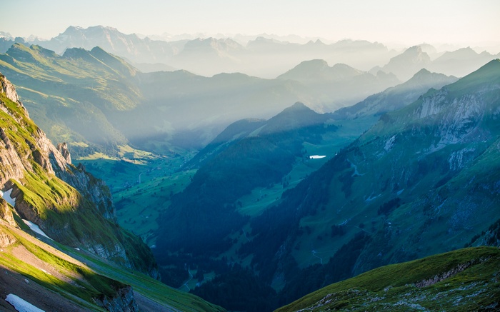Sunlight over misty Alps mountains in Switzerland