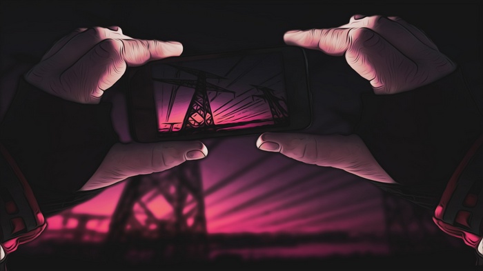 Hands holding a smartphone with power lines at sunset