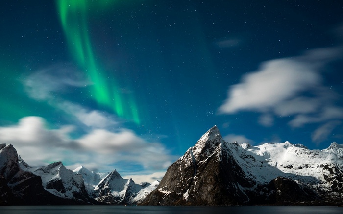 Aurora Borealis over snow-capped mountains and water