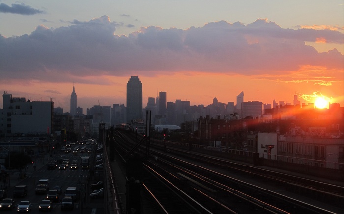 New York City skyline at sunset with traffic and train tracks