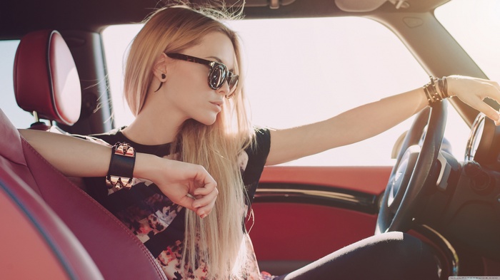 Woman with blonde hair driving a car