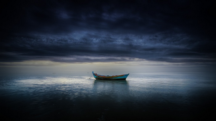 A lone boat on the sea under dark clouds