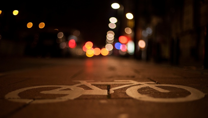 Urban street at night with bokeh lights and bicycle lane