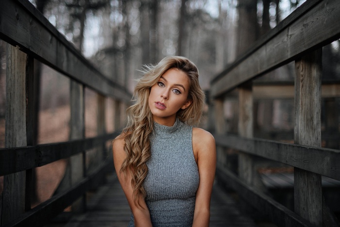 Woman with blonde hair on a wooden bridge