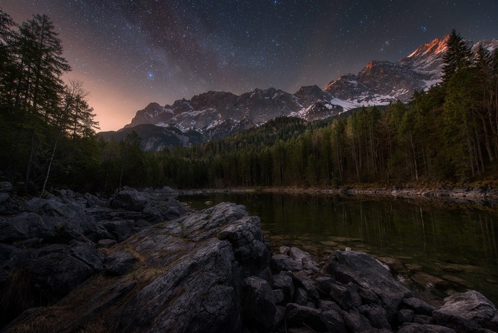 Mountain lake under a starry night sky