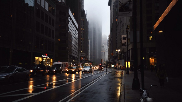 Rainy New York City street with traffic and tall buildings
