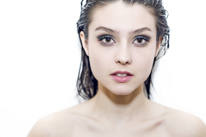 Portrait of a young woman with wet hair and dark eye makeup