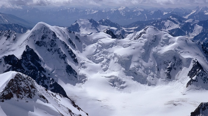 Snow-covered mountains under a cloudy sky