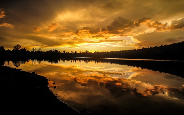 Sunset over a lake with dramatic clouds