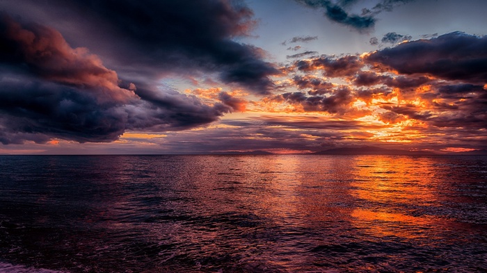 Dramatic sunset over the sea with dark clouds