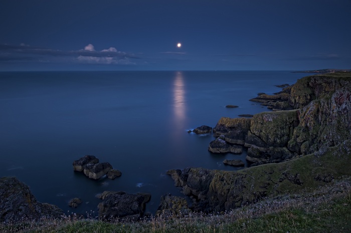 Moonlit sea and rocky coast of Scotland