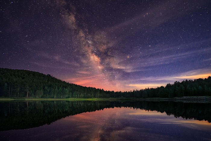 Milky Way over a forest lake reflection