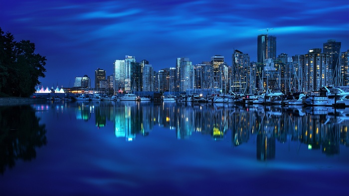 Vancouver skyline at night with boats in the harbor