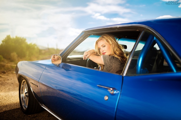 Blonde woman in a blue Chevrolet Camaro