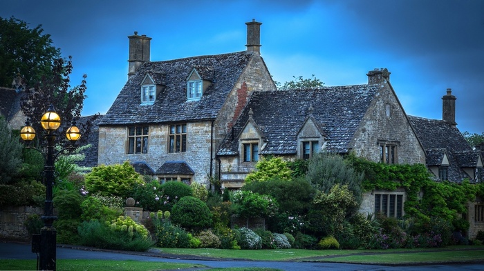 Stone cottage with a garden and a lamp post