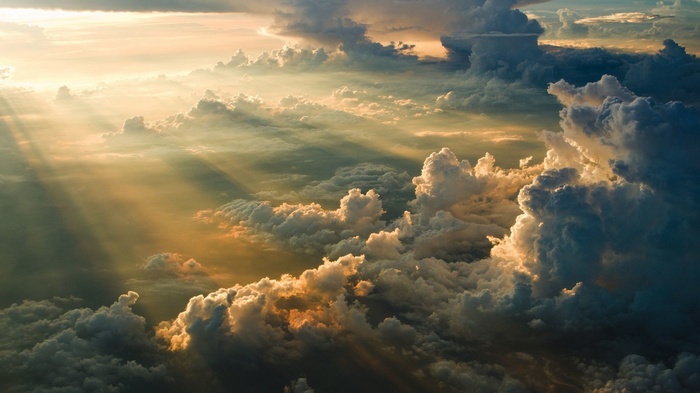 Sun rays shining through clouds from aerial view
