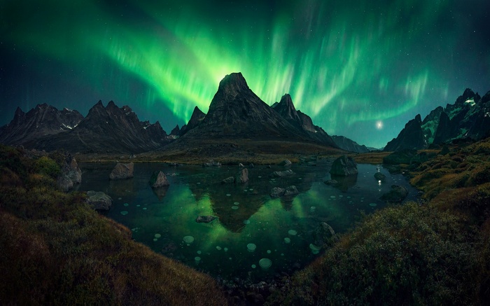Aurora Borealis over Greenland mountains and lake
