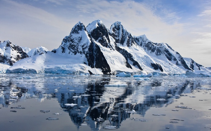Snow-capped mountains reflected in the sea