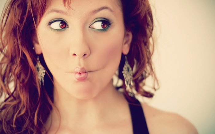 Woman with red hair making a fish face