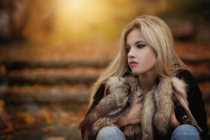 Woman in fur coat in autumn park