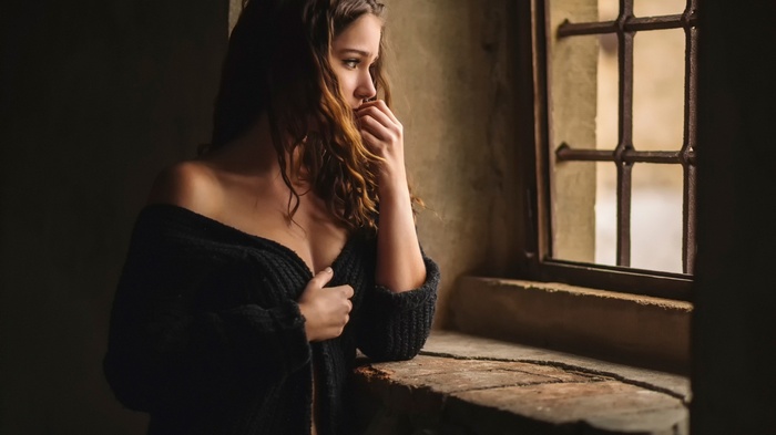 Woman with long wavy brunette hair looking away