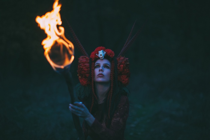 Woman in costume holding a flaming torch