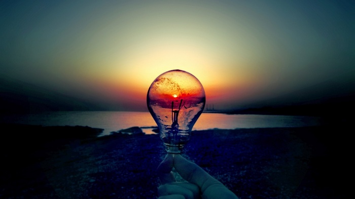 Light bulb with sunset over the sea