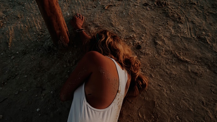 Ashley Benson lying on the sand