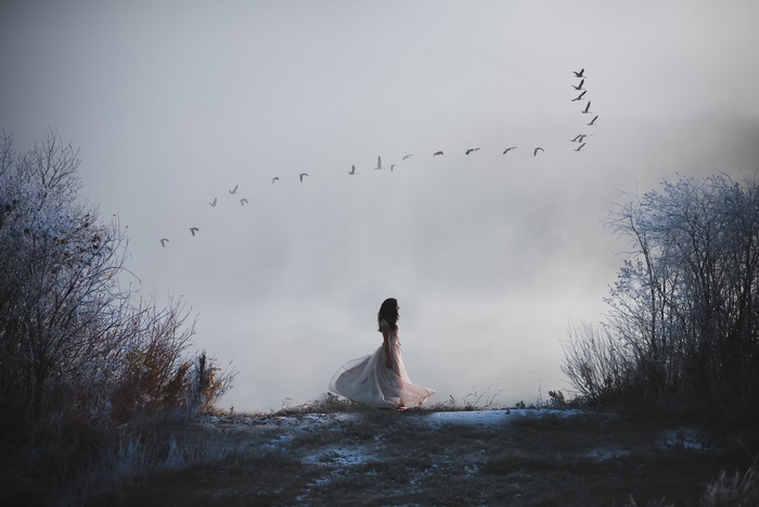 Woman in a dress with birds flying in formation