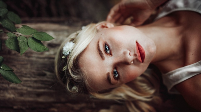 Woman with blonde hair and red lipstick lying down