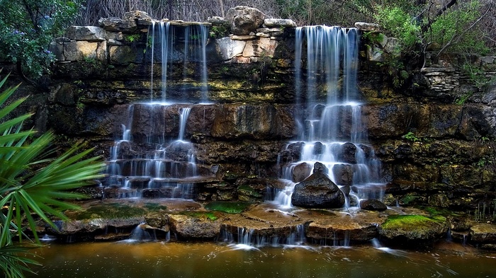 Multi-tiered waterfall cascading over rocks into a pool