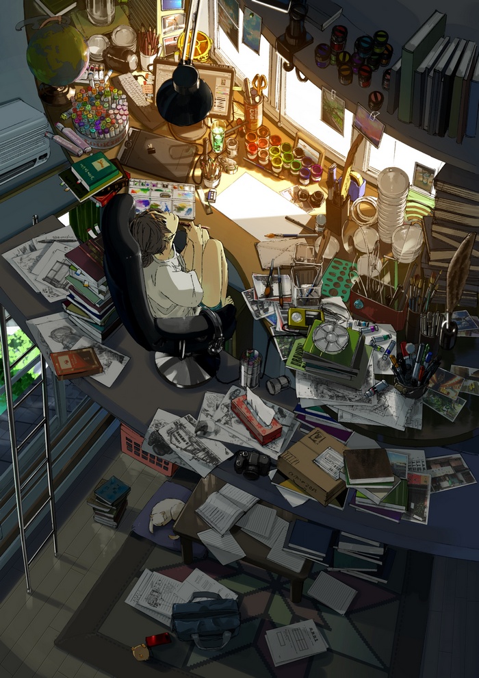 Artist's cluttered desk with a person and cat