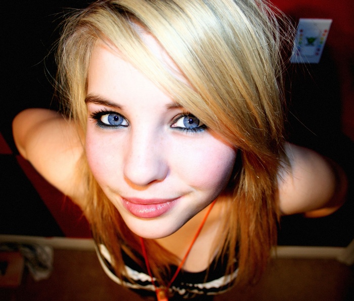 Young blonde woman with blue eyes looking up