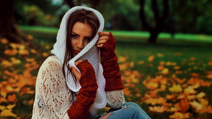 Woman in white sweater and red fingerless gloves in a park