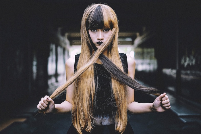 Woman with two-toned hair in a dark setting