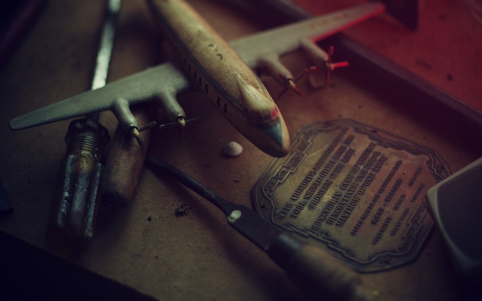 Vintage toy airplane and tools on a surface