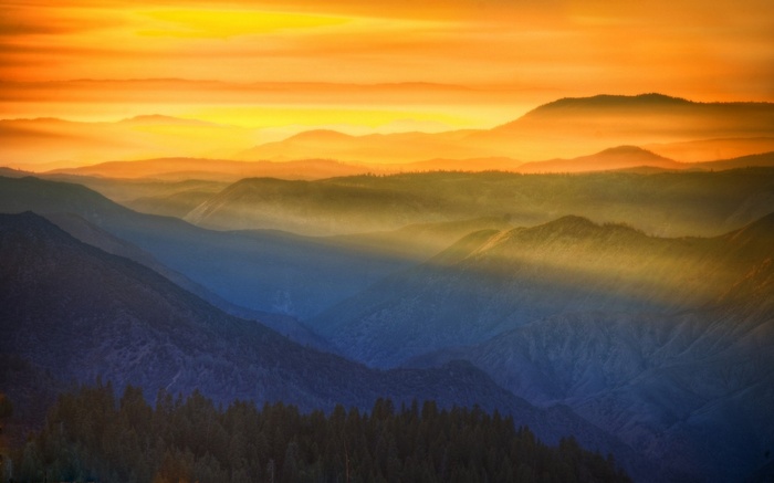 Sunset over mountains in Yosemite National Park with sun rays