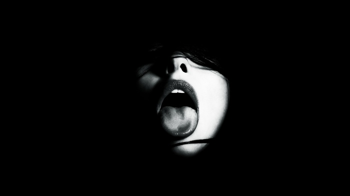 Woman with open mouth and tongue out in monochrome