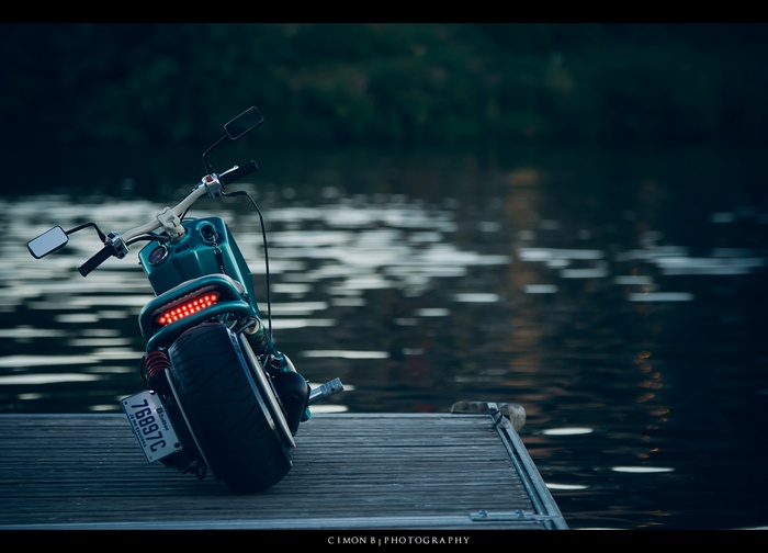 Teal scooter on a wooden dock by the water