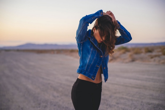 Woman in jean jacket and black pants in desert