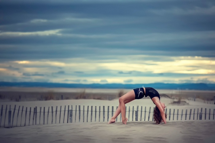 Woman doing gymnastics on a sandy beach