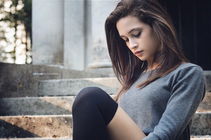 Woman with knee-highs and sweater sitting on steps
