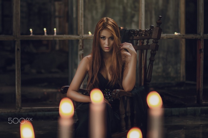 Redhead woman in black dress sitting in a chair