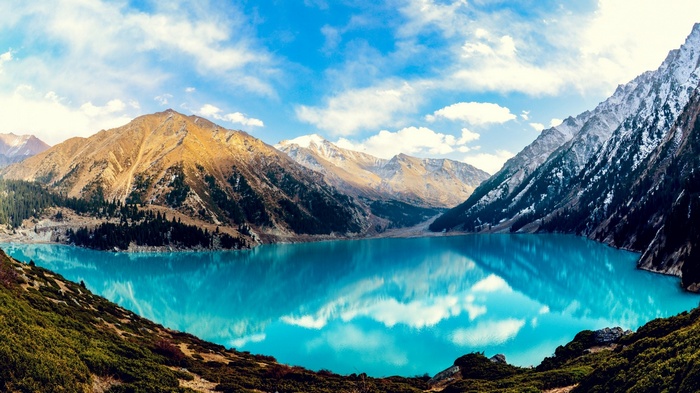 Turquoise lake surrounded by mountains and forests