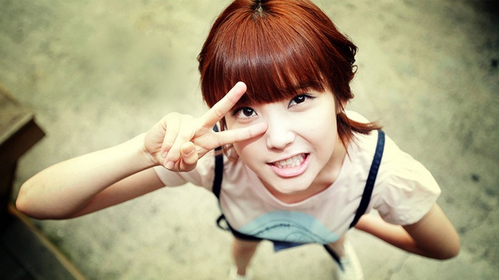 Asian woman with red hair making peace sign