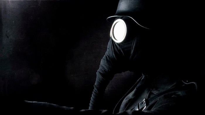 Soldier in gas mask and hat, dark background