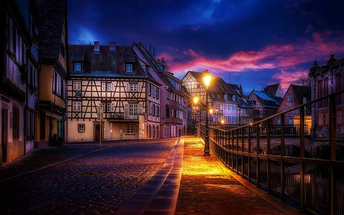 Street in Colmar, France at Dusk with Canal and Bridge
