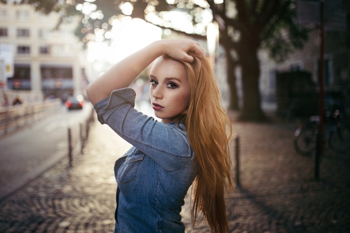 Woman with blonde hair touching her hair