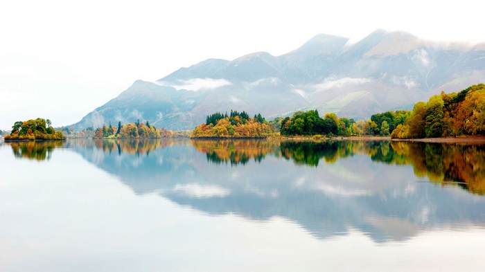 Autumnal Islands Reflected in a Lake with Misty Mountains
